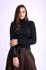 Maletă negru cu guler înalt și nasturi aurii pe manșete, din material moale și elastic, purtată de model.