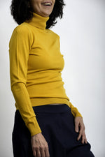 Maletă roșie cu mânecă lungă și croială ajustată, purtată într-o ținută casual.