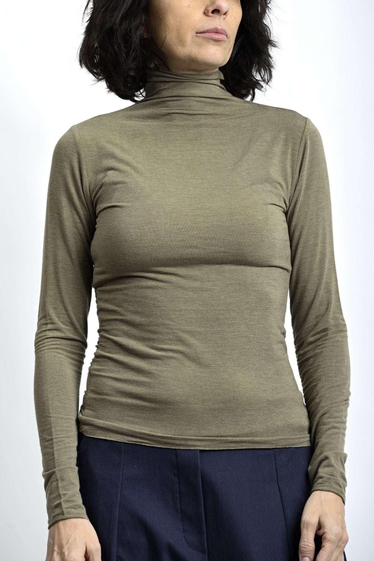 Maletă subțire crem, cu guler înalt și decupaj pentru deget, purtată ca strat de bază.