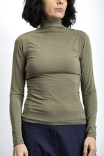 Maletă subțire crem, cu guler înalt și decupaj pentru deget, purtată ca strat de bază.