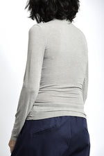 Spatele maletei subțiri fără tiv, cu croială mulată și linie curată.