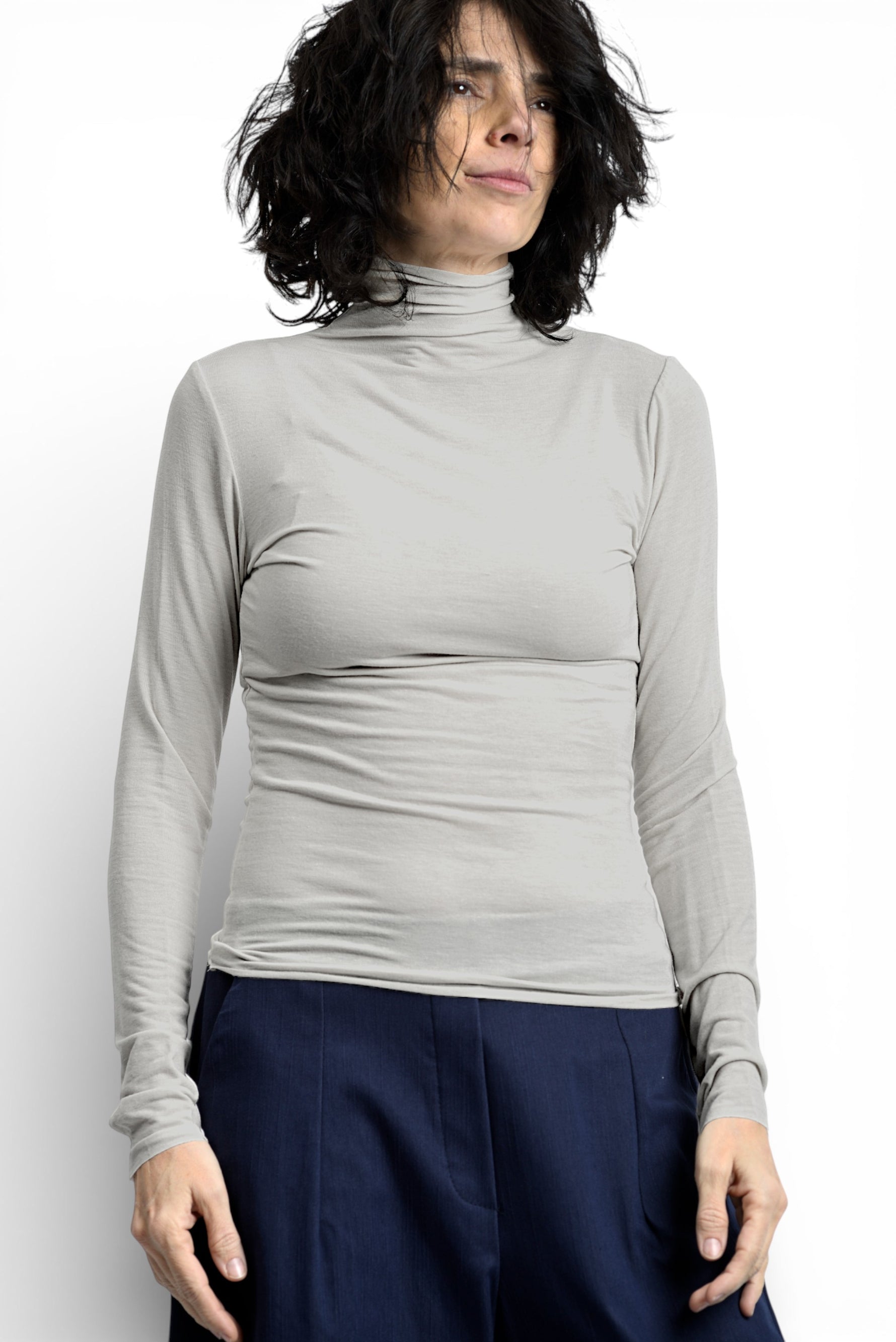 Maletă subțire crem, cu guler înalt și mâneci lungi, croială mulată, purtată ca strat de bază.