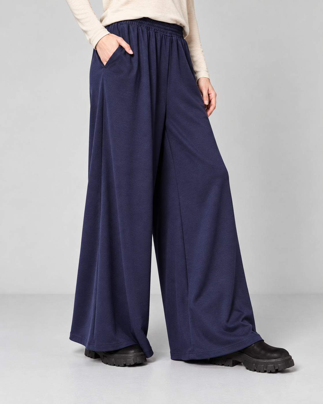 Pantaloni palazzo bleumarin din jerse fluid, cu talie elastică și buzunare laterale, vedere din față - All Above Boutique