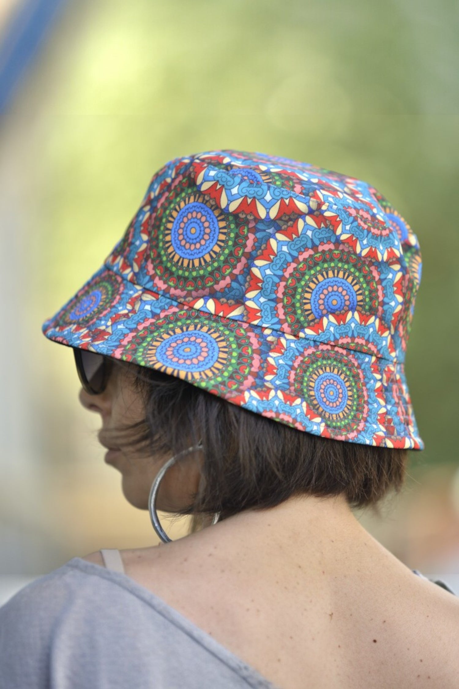 Detaliu lateral al pălăriei unisex cu imprimeu geometric viu colorat și boruri mici