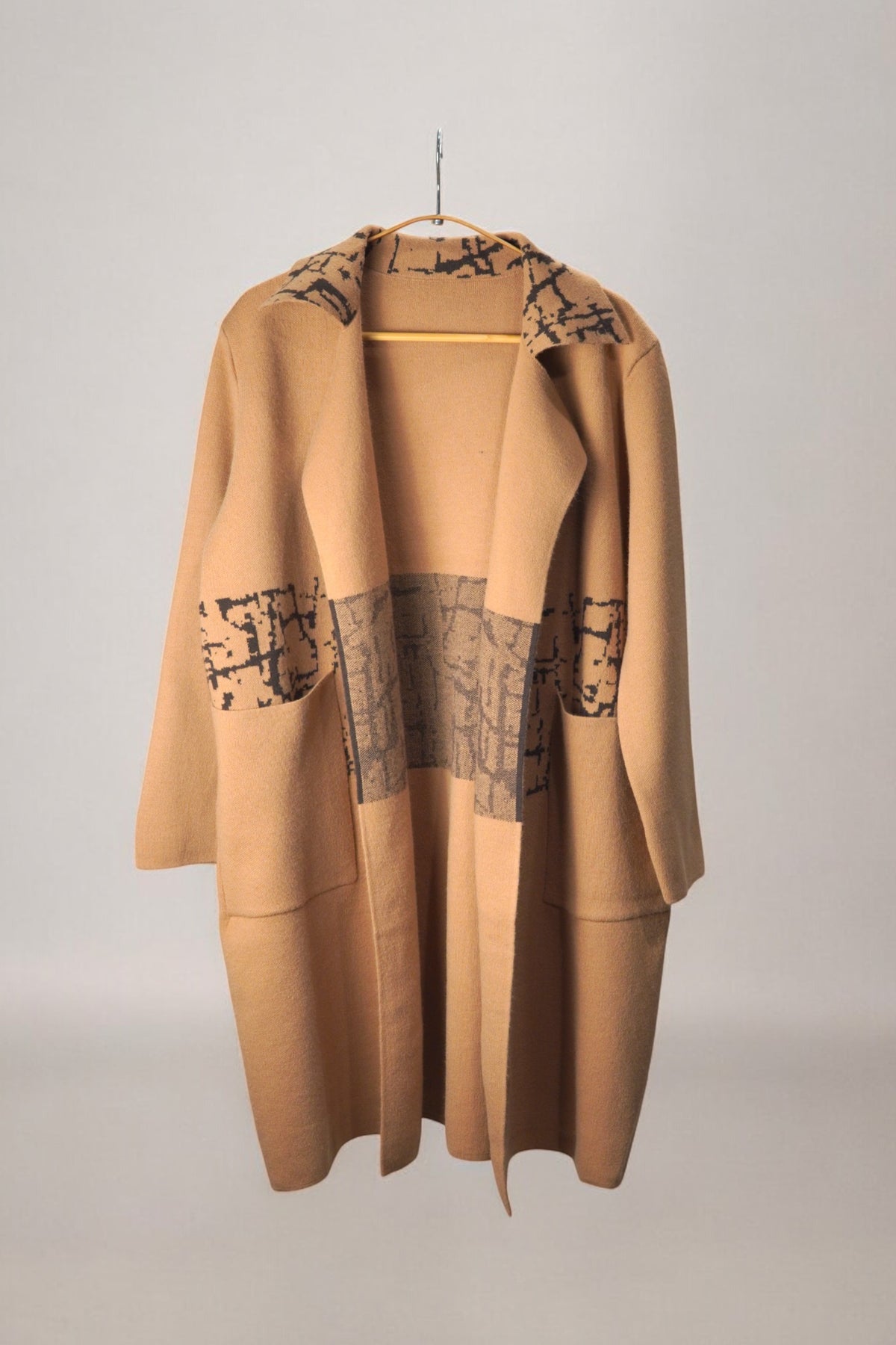 Palton bej elegant cu imprimeu abstract negru, model larg și buzunare aplicate.