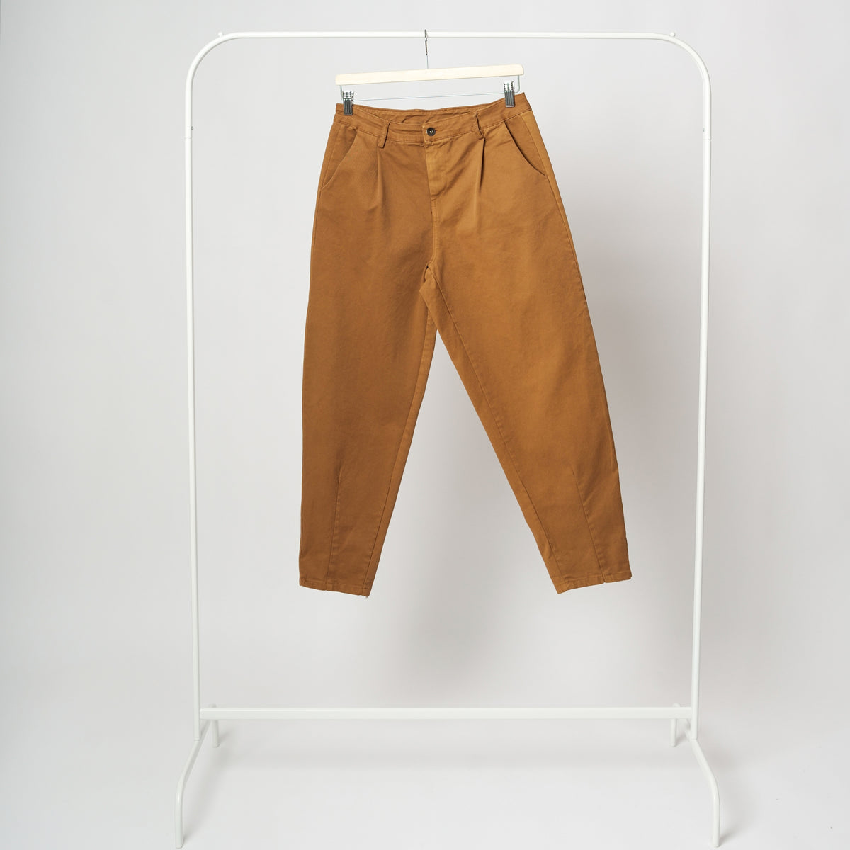 Vedere frontală a pantalonilor tip baggy, culoare cărămizie, talie înaltă și pense elegante.

