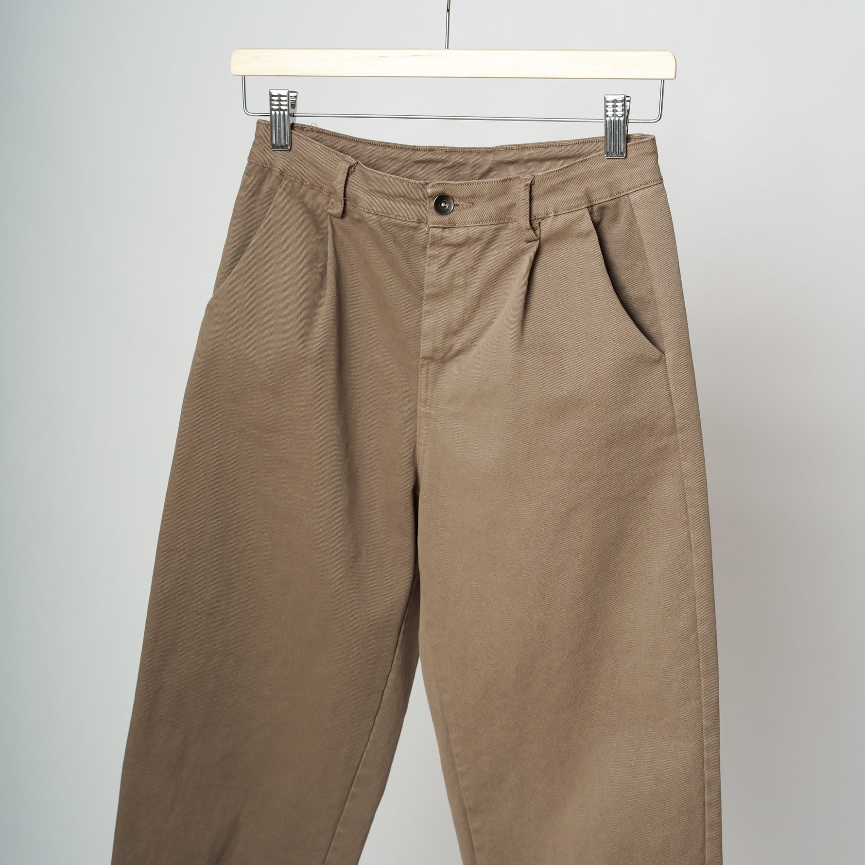 Detaliu buzunar și talie înaltă a pantalonilor grej tip baggy din bumbac și elastan.