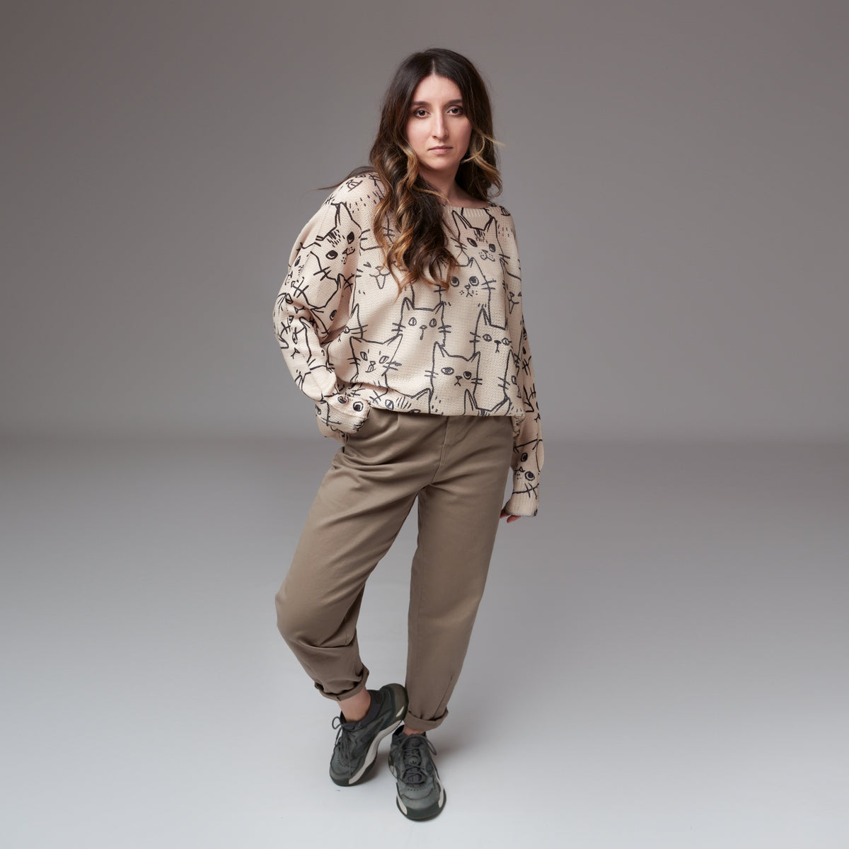 Pantaloni grej tip baggy purtați cu mansete îndoite și bluză oversize cu imprimeu pisici.