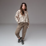 Pantaloni grej tip baggy purtați cu mansete îndoite și bluză oversize cu imprimeu pisici.