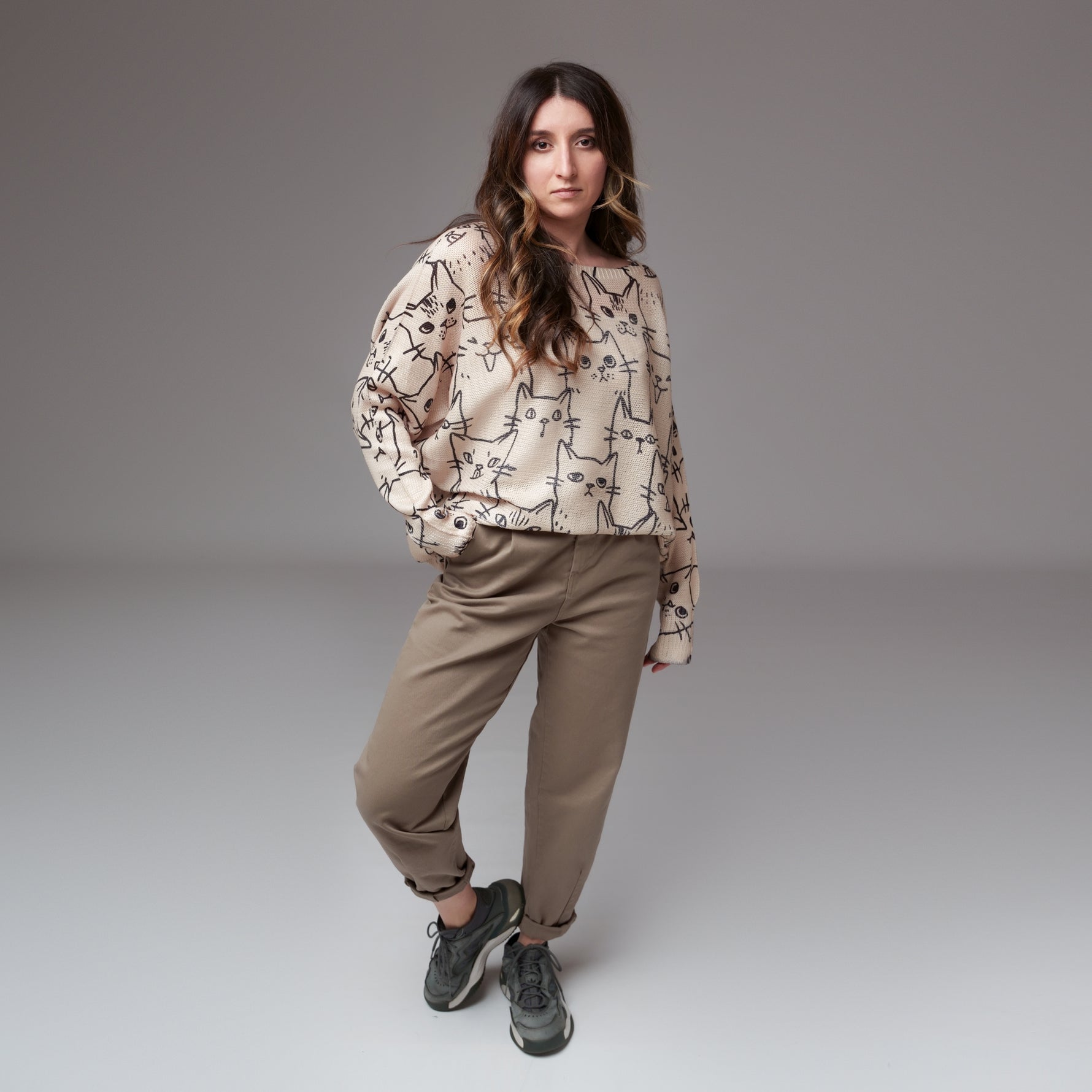 Pantaloni grej tip baggy purtați cu mansete îndoite și bluză oversize cu imprimeu pisici.