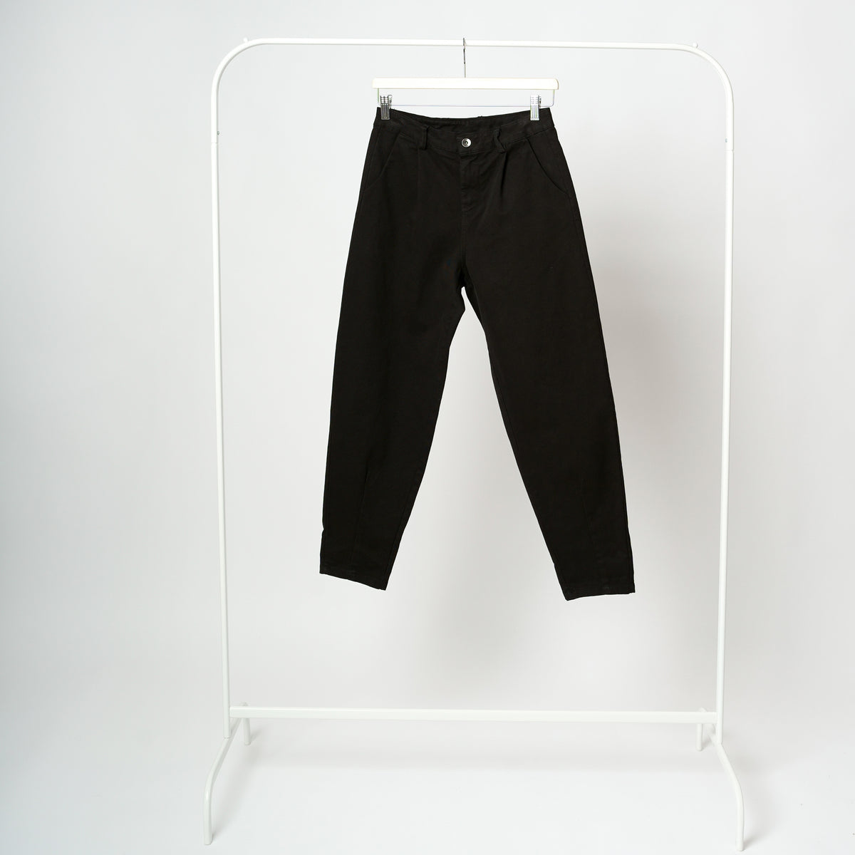 Pantaloni negri cu aspect baggy, cu buzunare frontale și croială relaxată spre gleznă.