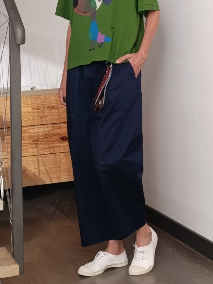 Pantaloni barrel bleumarin cu talie elastică, purtați cu tricou verde casual