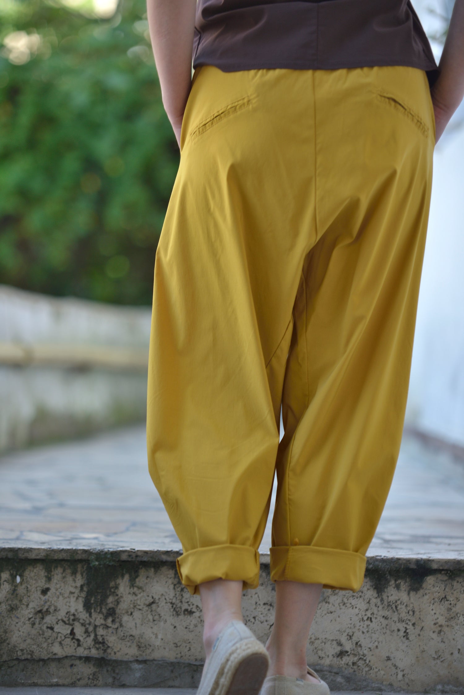 Spatele pantalonilor barrel galbeni, cu pense decorative și betelie lată