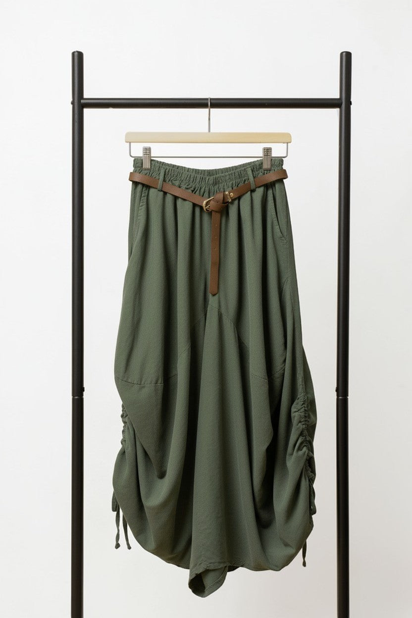 Pantaloni barrel kaki, croială lejeră cu șnur lateral și curea subțire, prezentați pe umeraș.