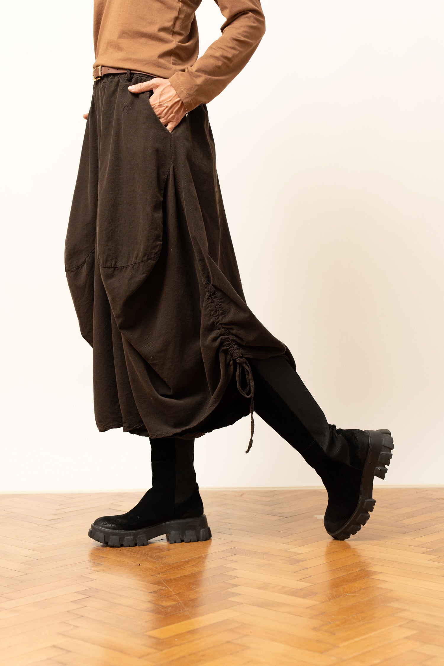 Pantaloni barrel maro, cu șnur lateral și croială lejeră, prezentați din lateral pe model.