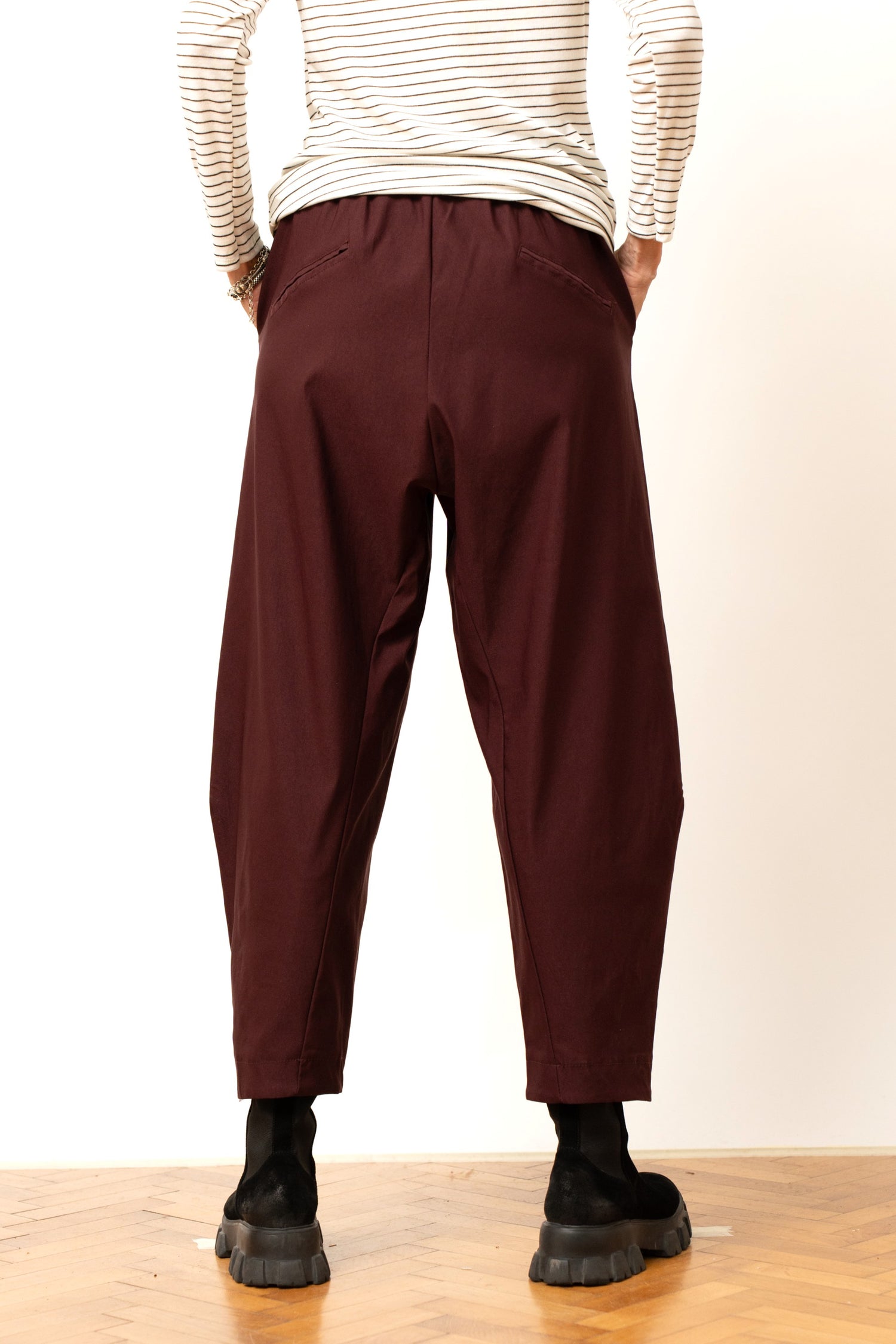 Pantaloni damă barrel vișinii, cu buzunare discrete și talie elastică, prezentați din spate.