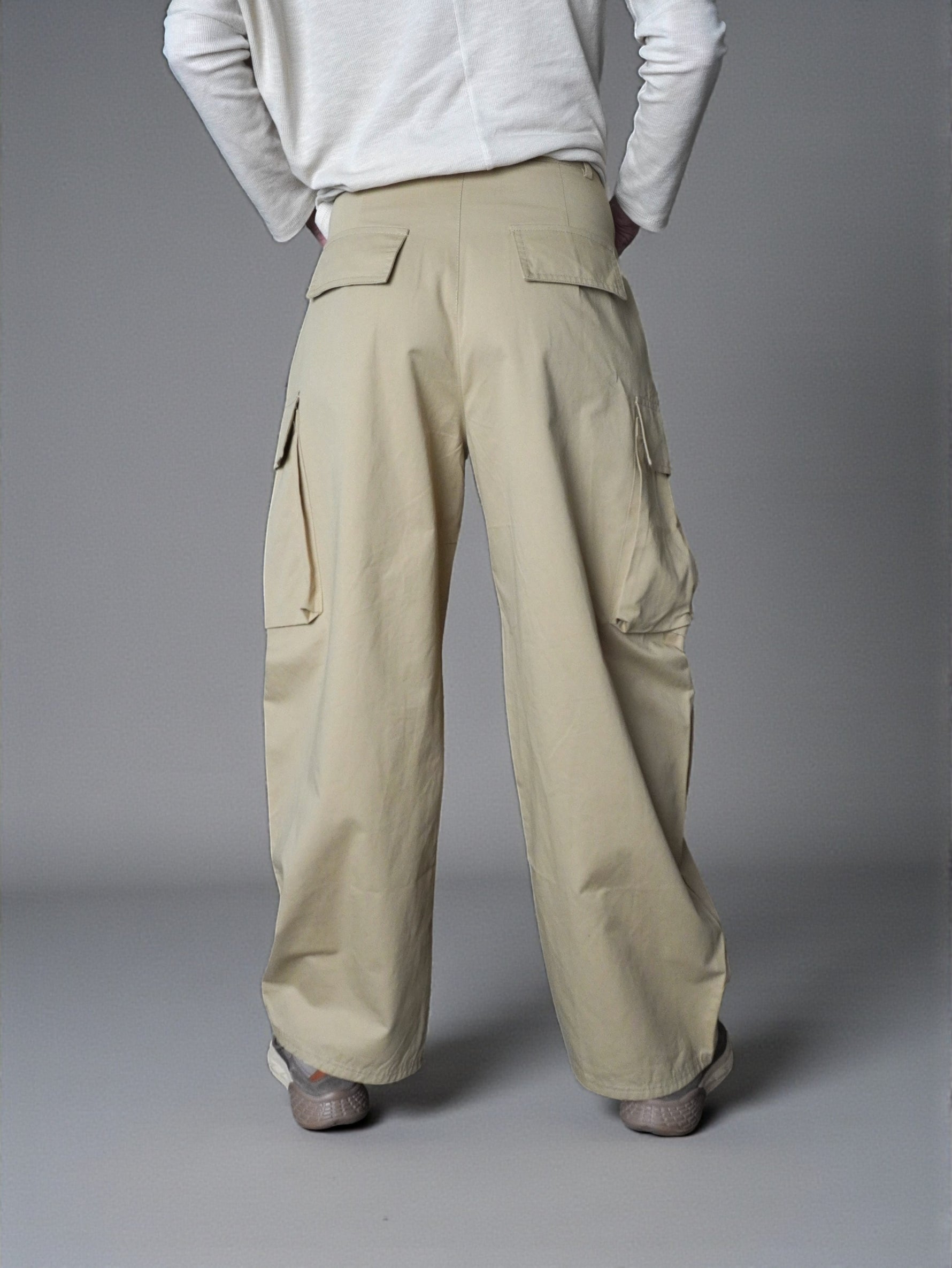 Pantaloni cargo bej cu talie înaltă, croială largă și buzunare aplicate, vedere din spate.
