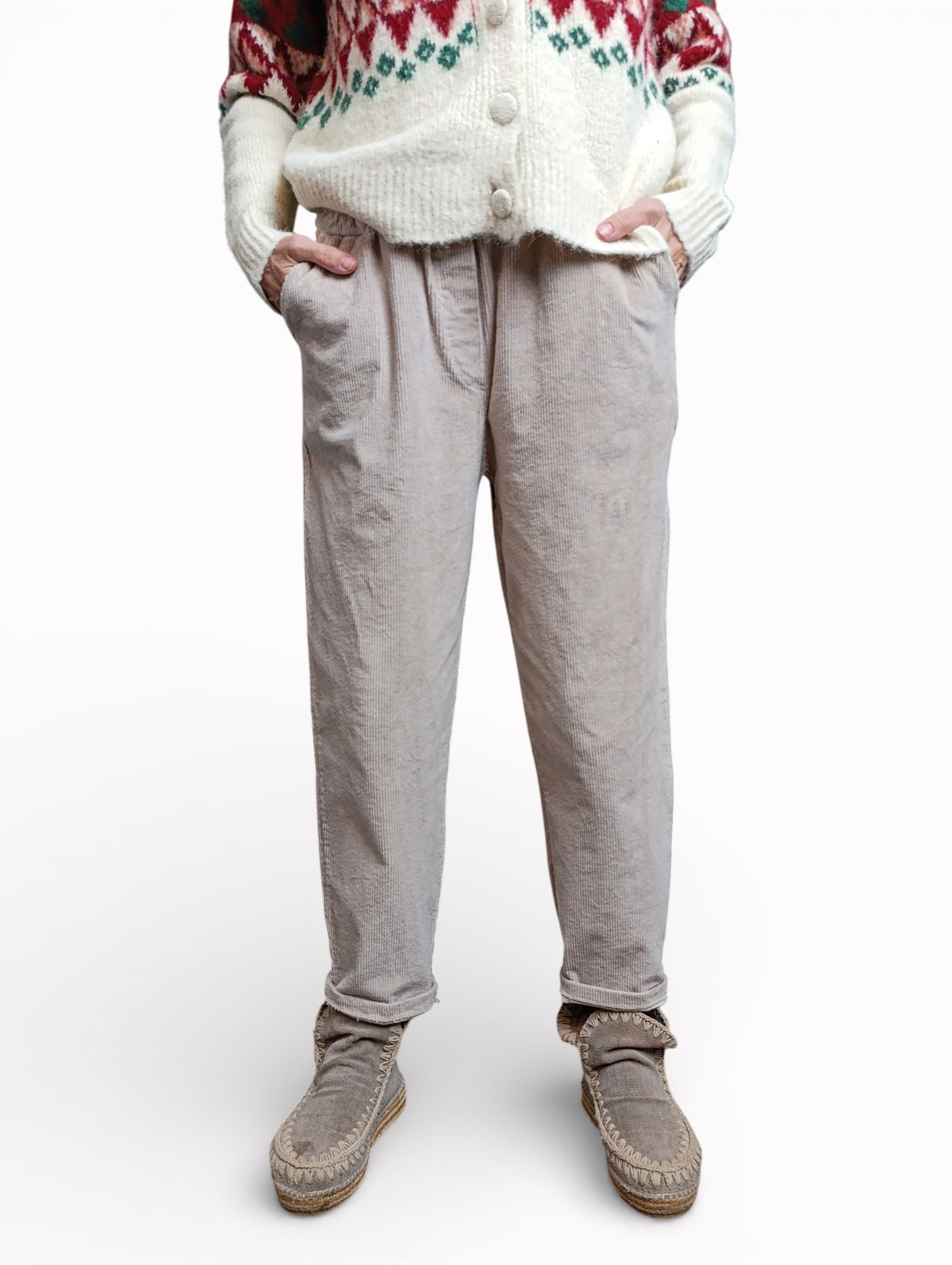 Model purtând pantaloni conici din catifea reiată crem, cu croială lejeră și talie elastică.