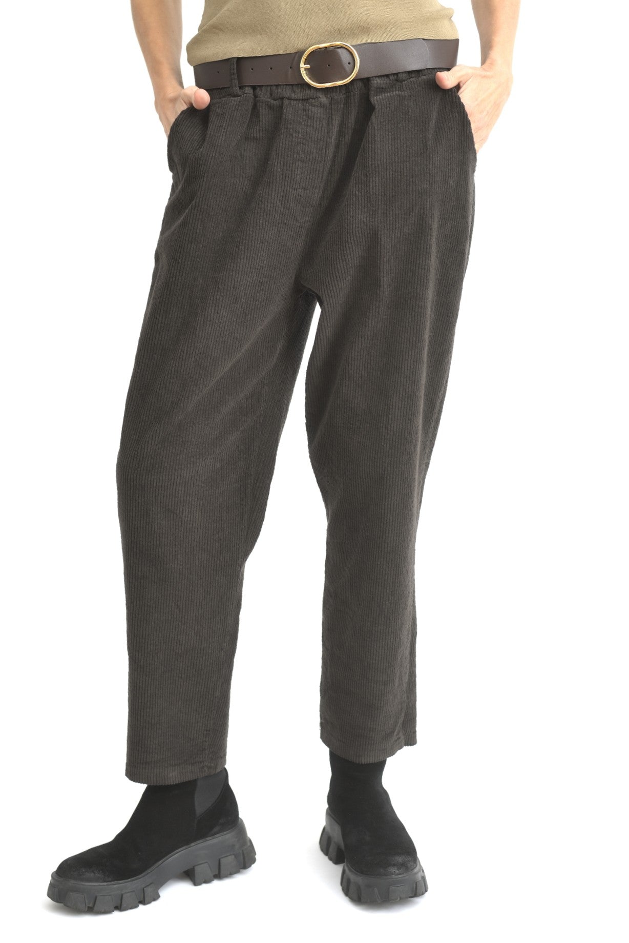 Pantaloni conici maro din catifea reiată, fotografiați din lateral pe model, cu manșete elastice.