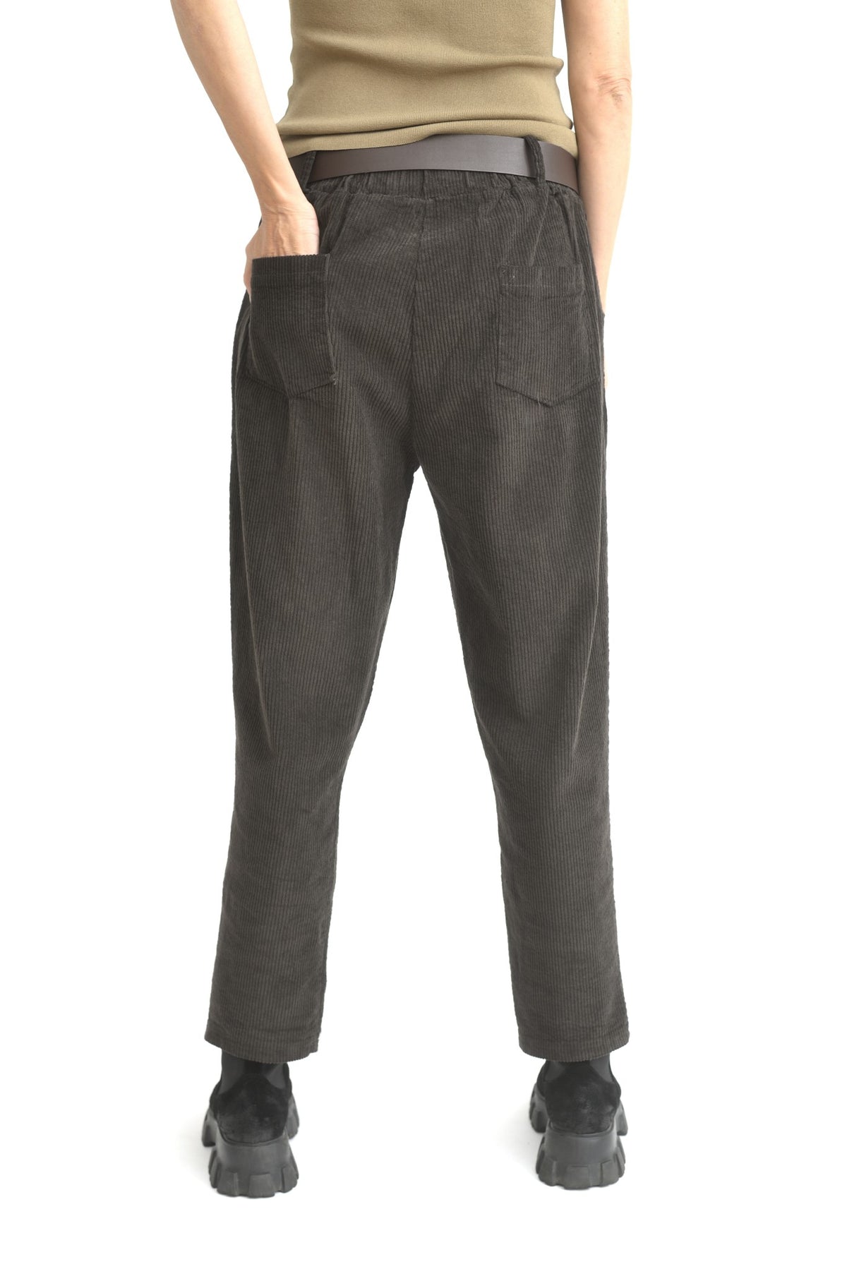 Pantaloni conici maro din catifea reiată, prezentați din spate, având croială elastică și textură groasă.