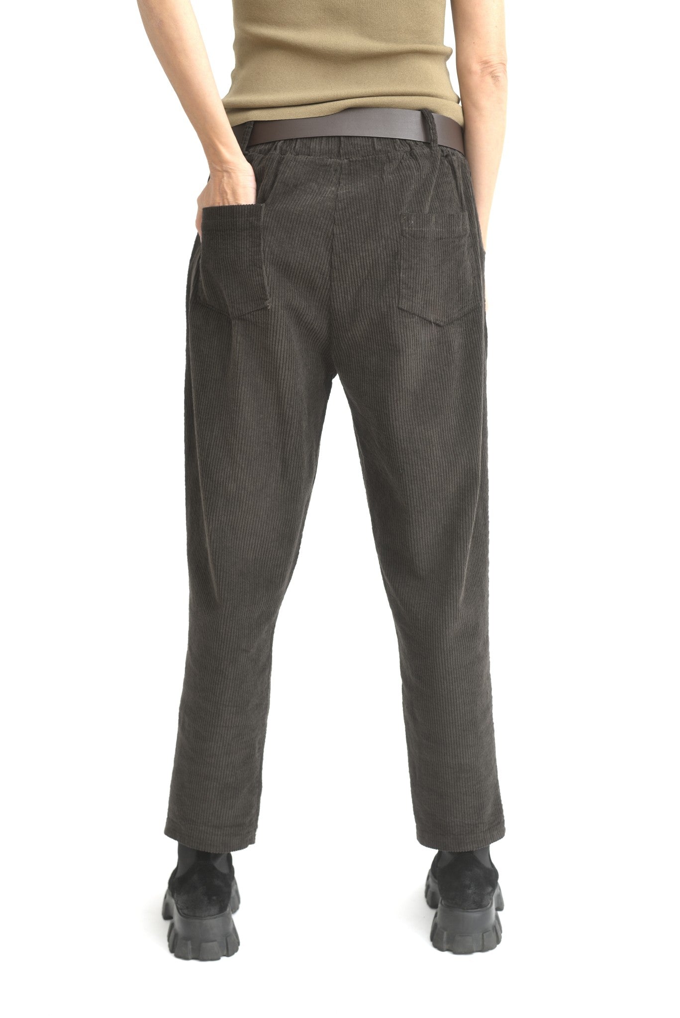 Pantaloni conici maro din catifea reiată, prezentați din spate, având croială elastică și textură groasă.