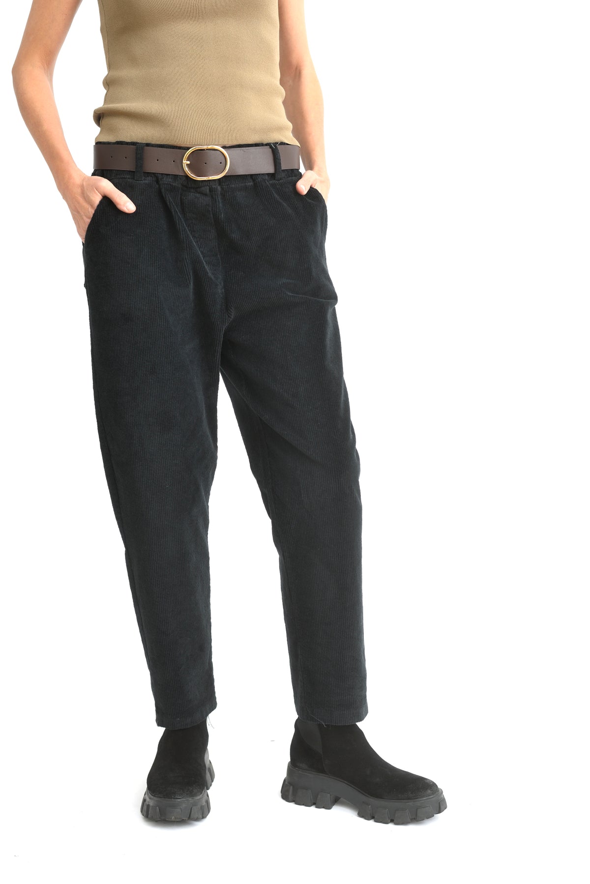 Model purtând pantaloni conici din catifea reiată negru, cu croială lejeră și talie elastică.