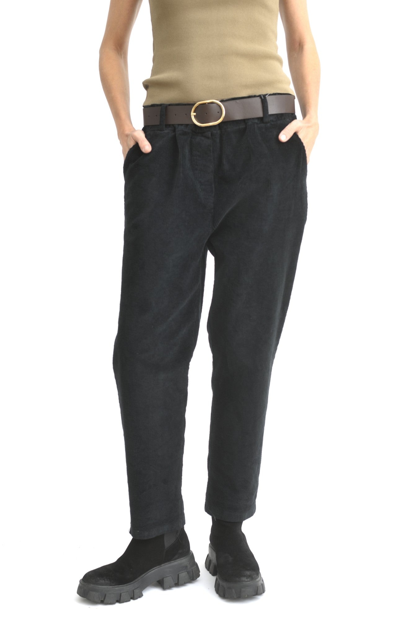 Pantaloni conici din catifea reiată în culoare neagră, prezentați din față pe model, cu talie elastică și buzunare laterale.