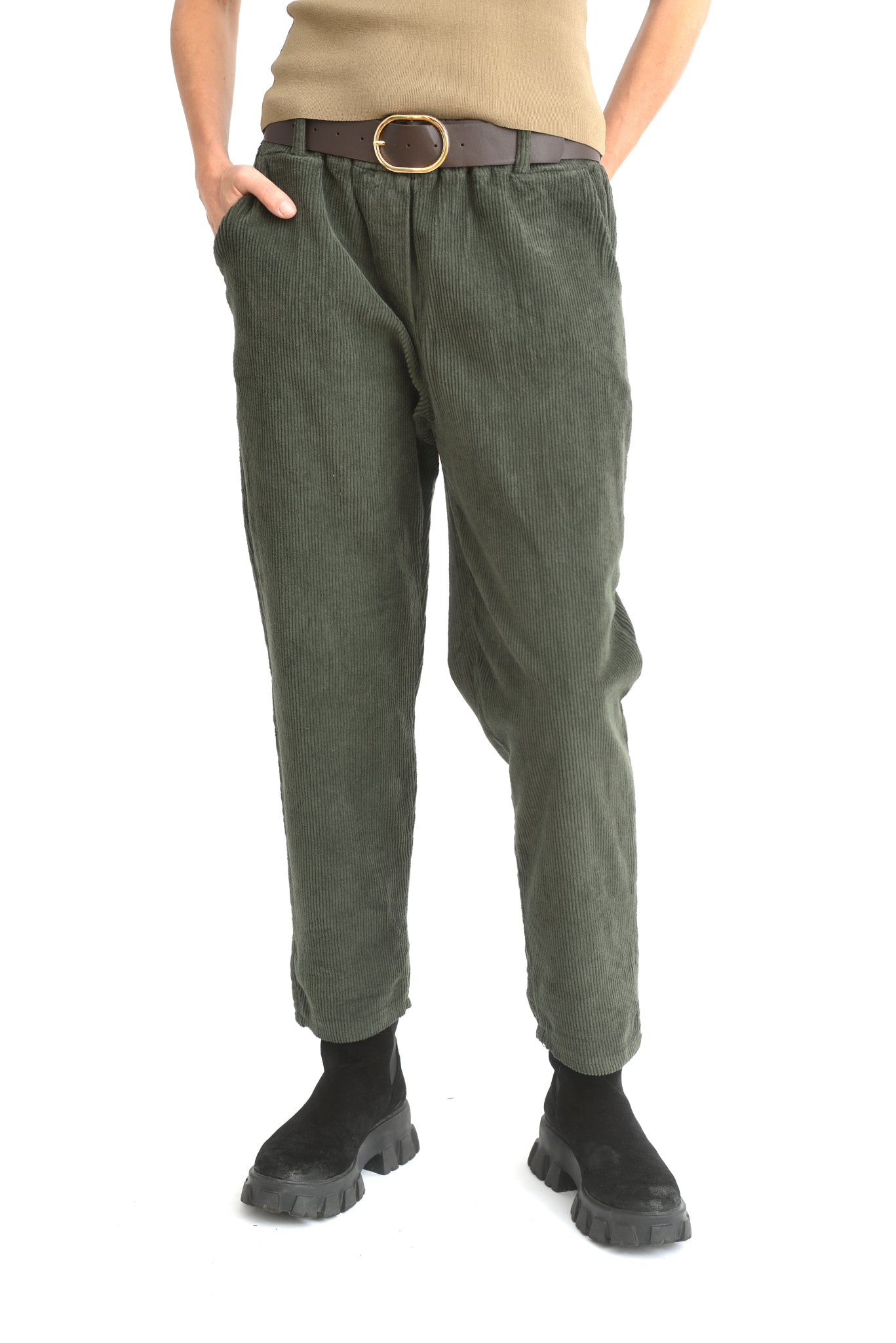 Pantaloni conici din catifea reiată oliv, ilustrați din lateral, evidențiind textura materialului și croiala conică.