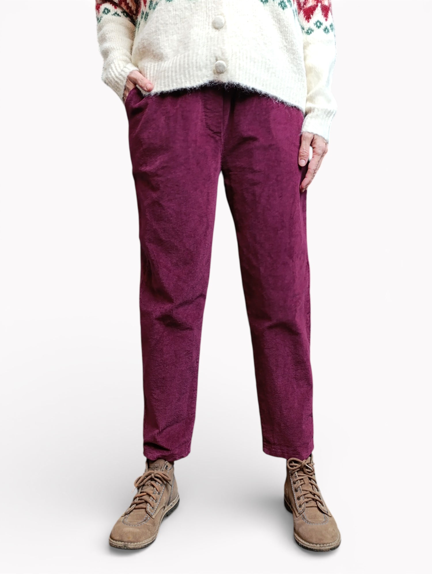 Model purtând pantaloni conici din catifea reiată visinii, cu croială lejeră și talie elastică.