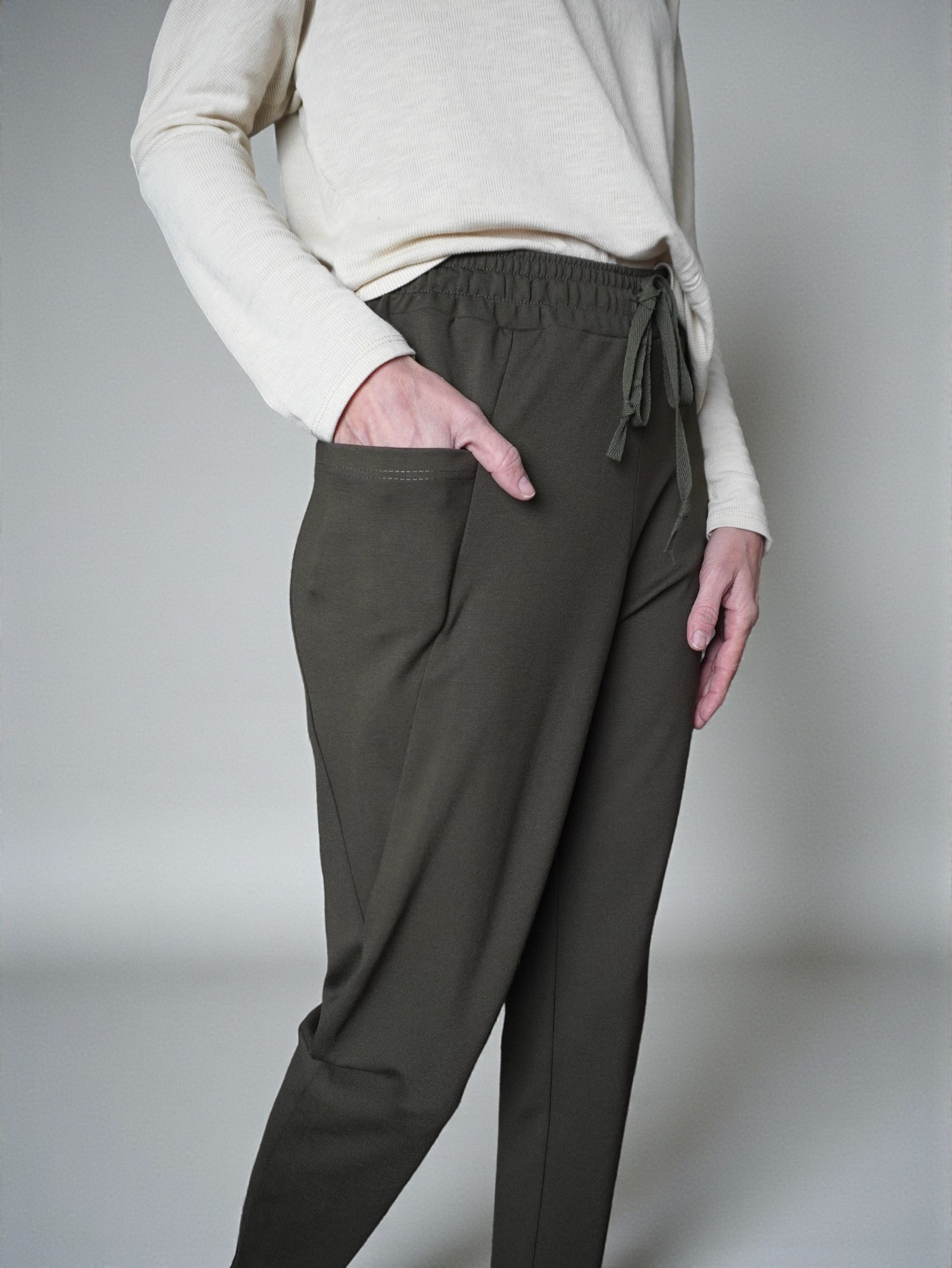 Detaliu talie cu șnur ascuns la pantaloni conici din jerse.