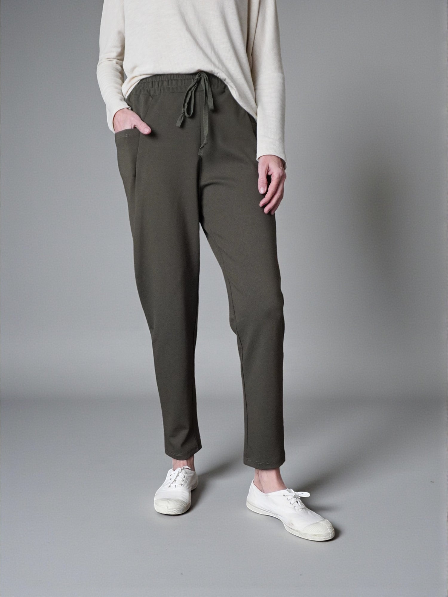 Pantaloni conici kaki, surprinși din profil, evidențiind croiala lejeră.