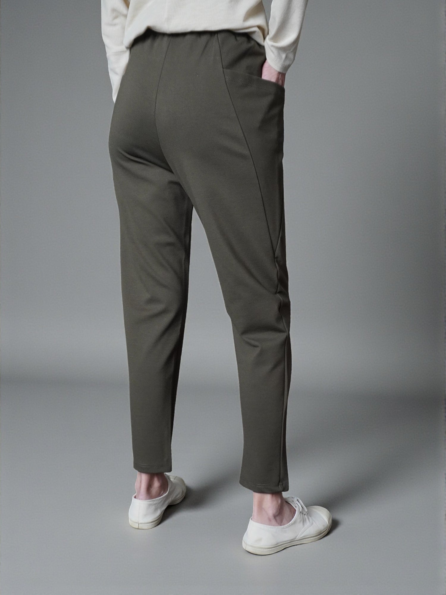 Pantaloni conici din jerse, vedere din spate, cu linie curată.