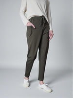 Pantaloni conici din jerse, culoare kaki, cu buzunare și talie reglabilă.