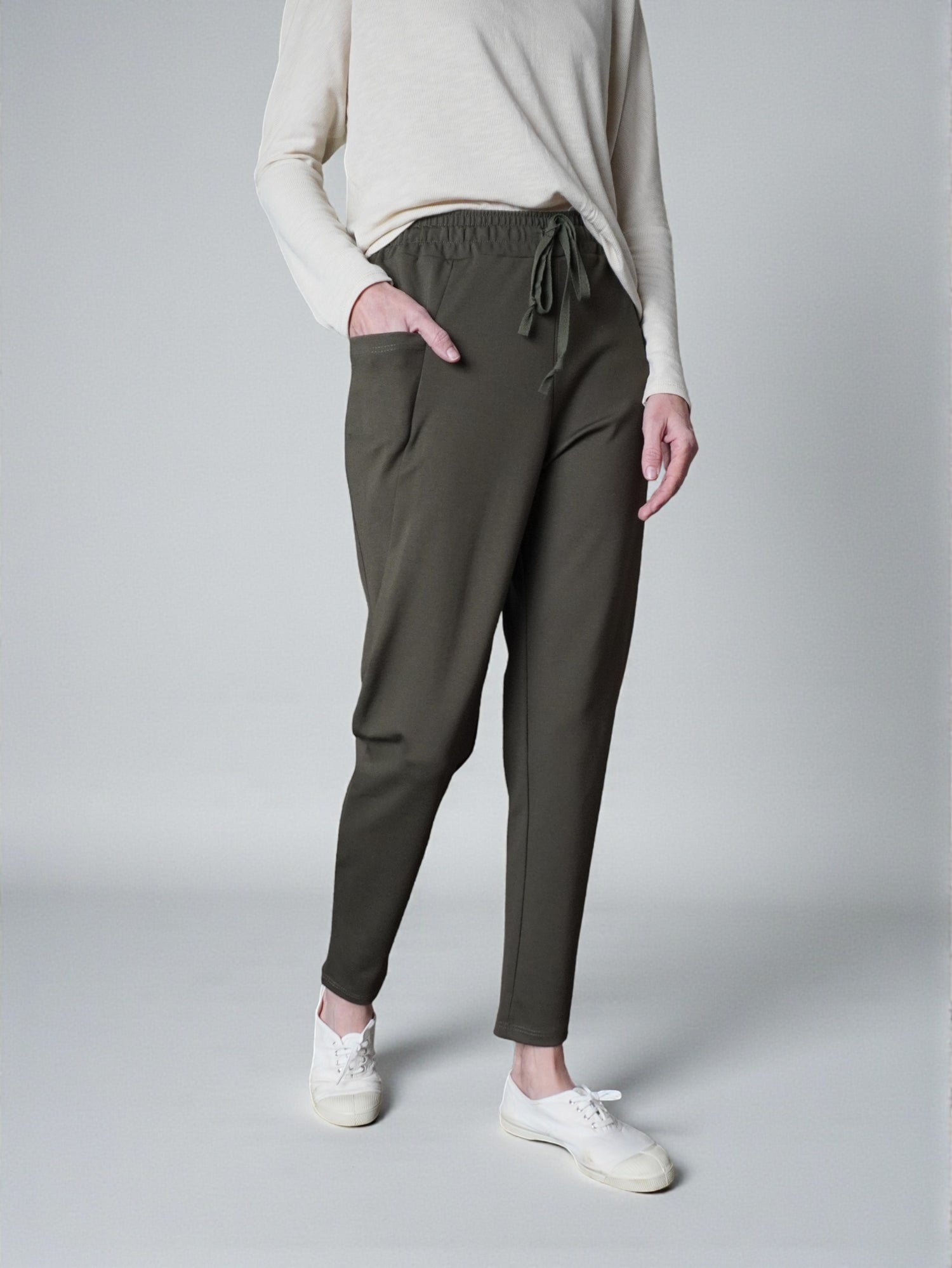 Pantaloni conici din jerse, culoare kaki, cu buzunare și talie reglabilă.