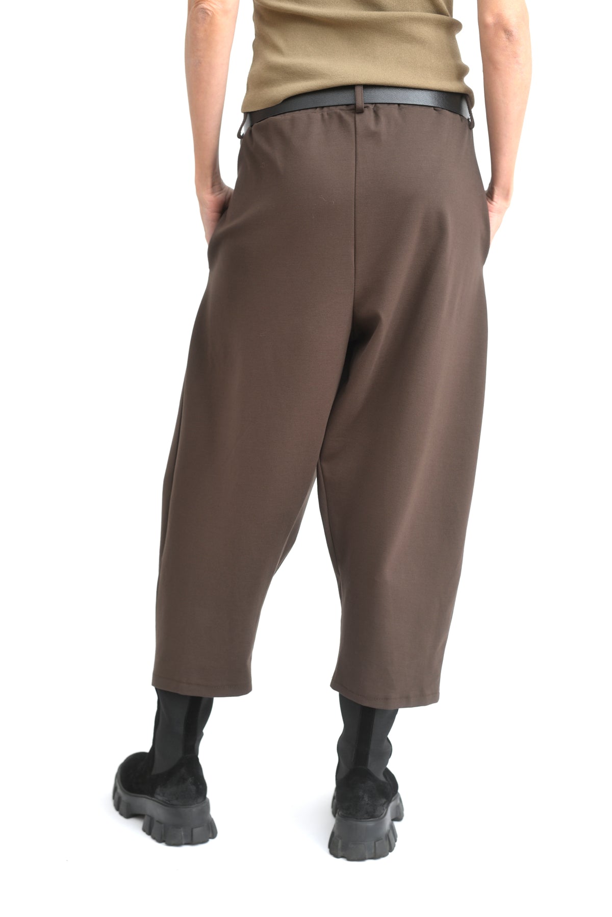 Pantaloni conici din jerse maro văzuți din lateral, talie elastică și croi relaxat.