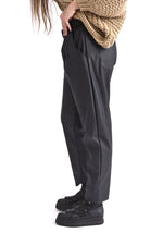 Vedere laterală a pantalonilor conici din piele ecologică, evidențiind textura moale și croiala modernă.