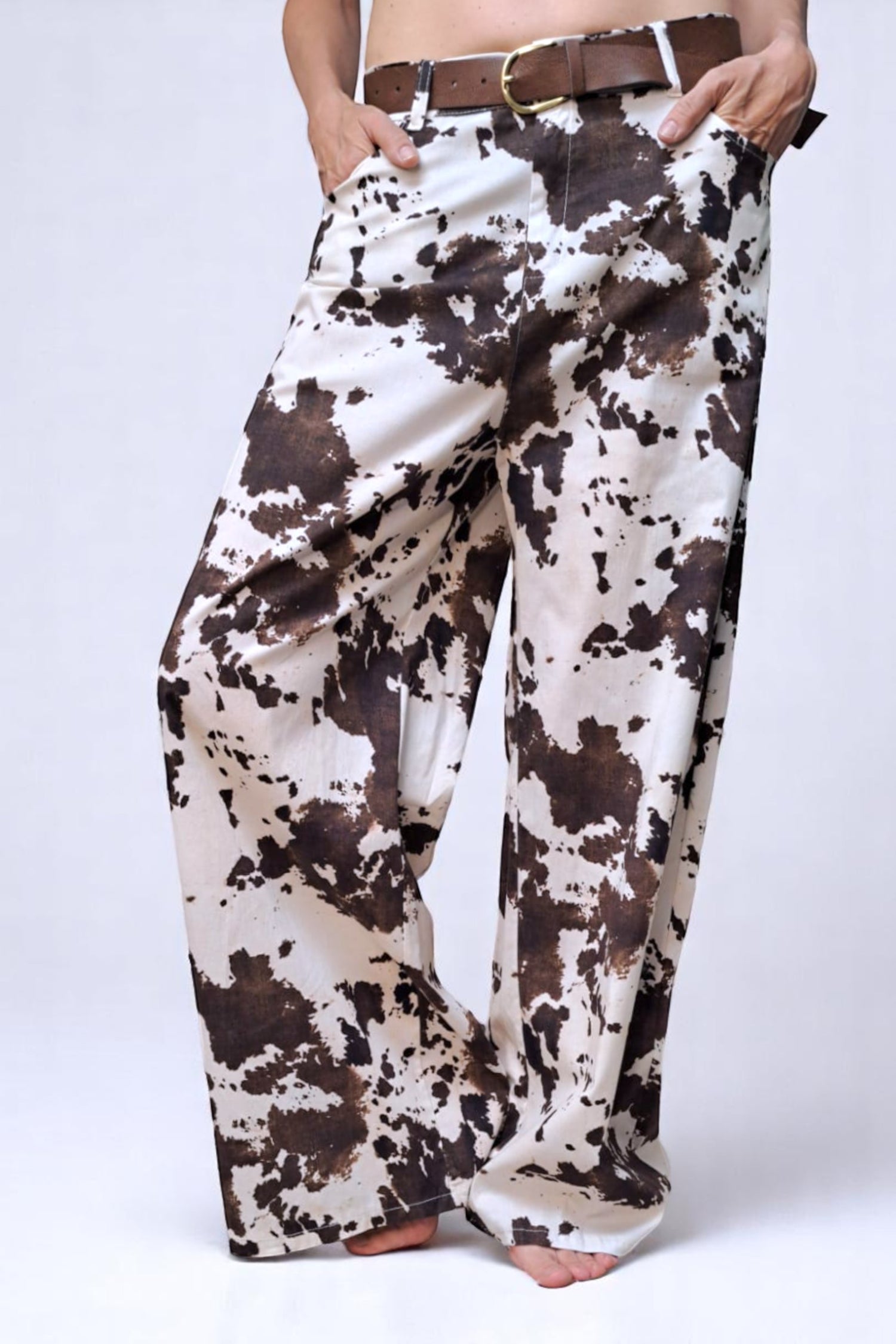 Pantaloni largi cow print văzuți din lateral, cu design amplu și talie confortabilă