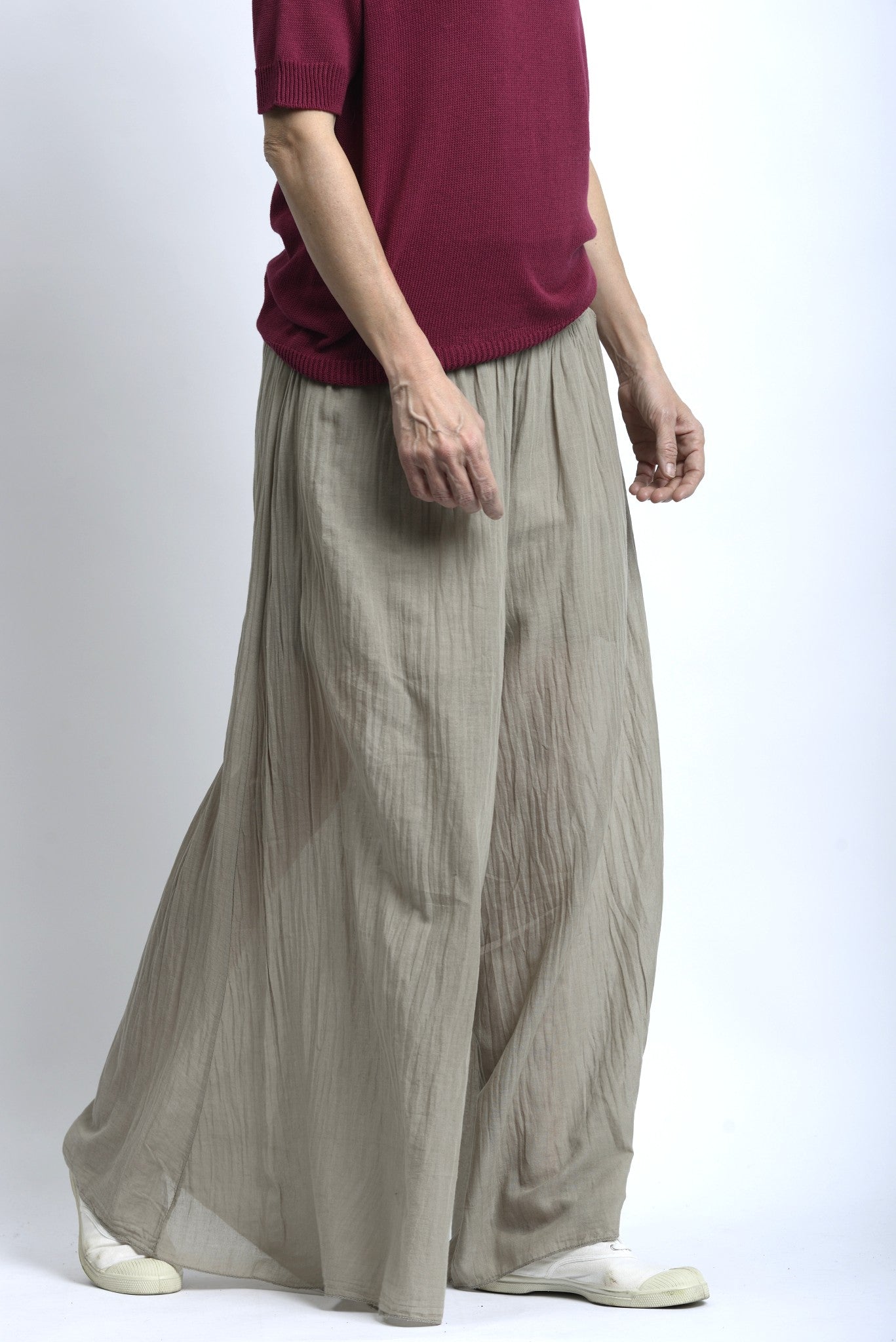 Vedere laterală a pantalonilor creponați din bumbac, cu talie jerse elastică și linie fluidă a piciorului.