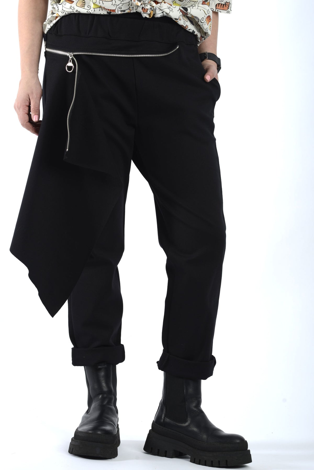 Pantaloni negri cu talie elastică și fustă detașabilă cu fermoar, design asimetric, purtați cu bocanci, vedere frontală.