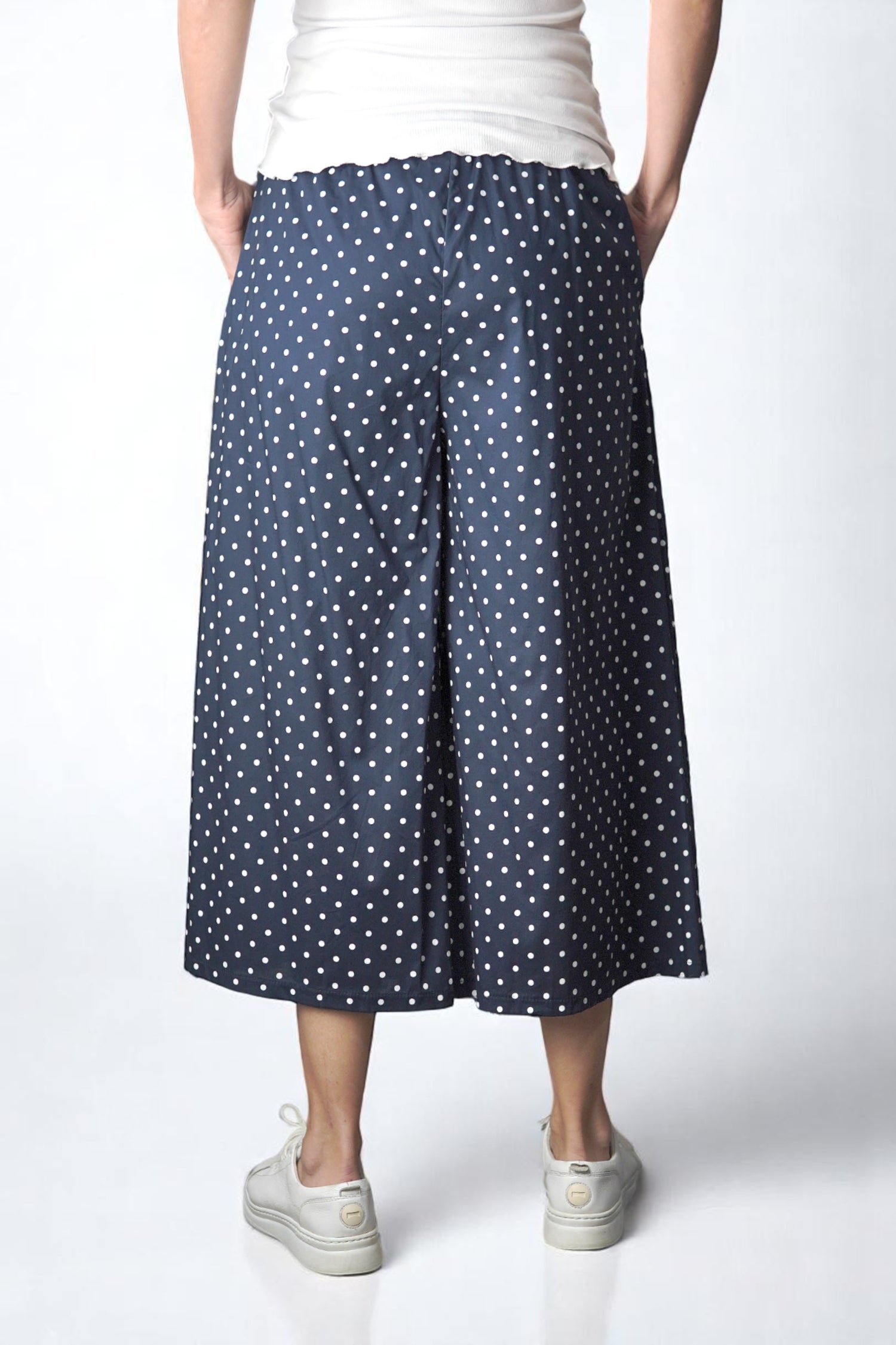 Spatele unui pantalon culottes bleumarin cu imprimeu cu buline și croială lejeră