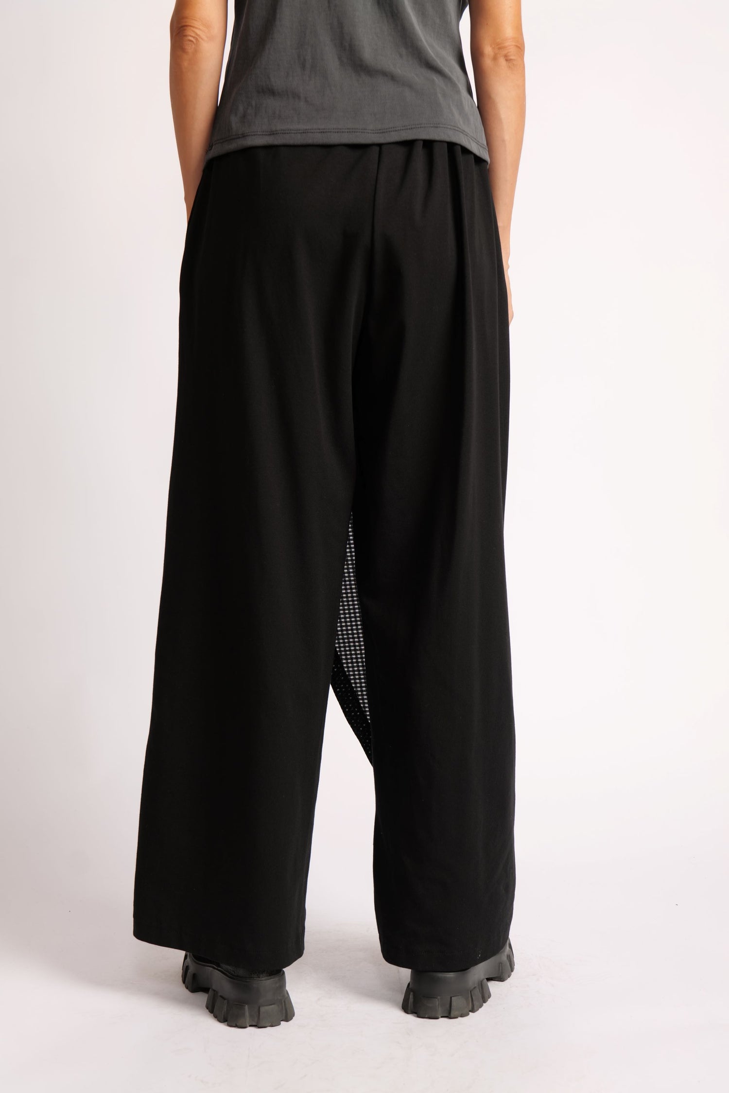 Pantaloni negri din jerse cu prindere tip pareo, croi lejer și design modern.