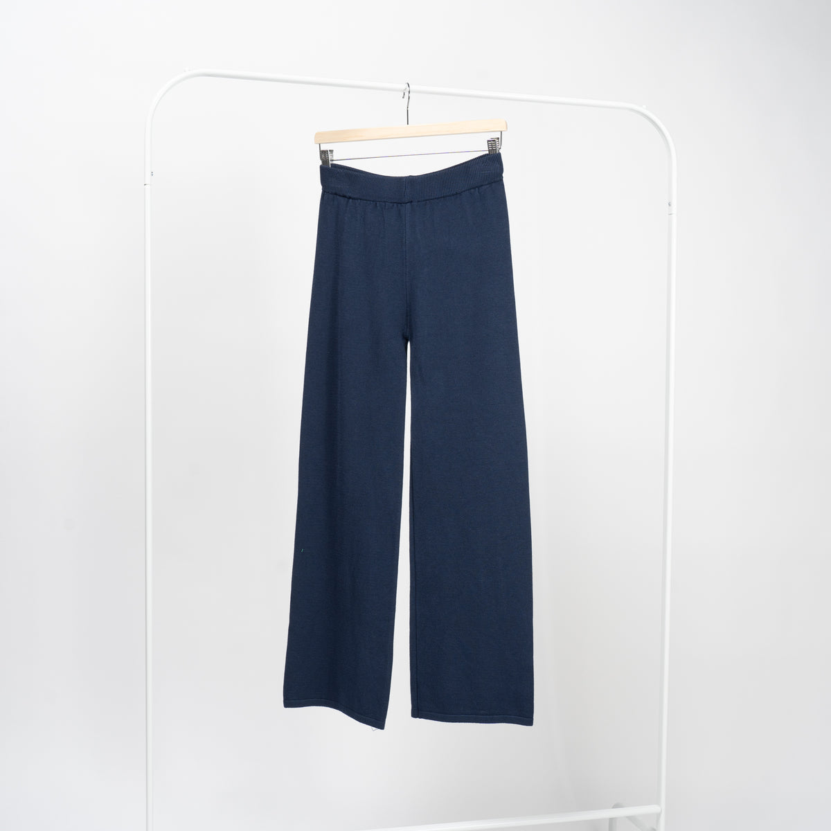 Pantaloni drepți bleumarin din tricot moale, talie înaltă elastică, picior drept, vedere frontală pe umeraș.