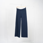 Pantaloni drepți bleumarin din tricot moale, talie înaltă elastică, picior drept, vedere frontală pe umeraș.