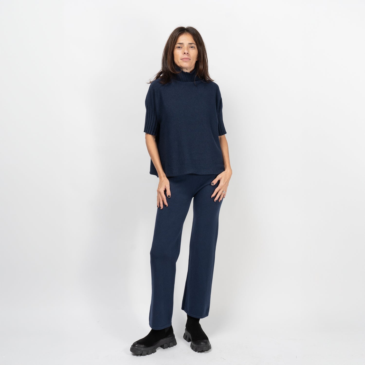Pantaloni drepți bleumarin din tricot soft, purtați de model; talie înaltă din rib, cădere lejeră.