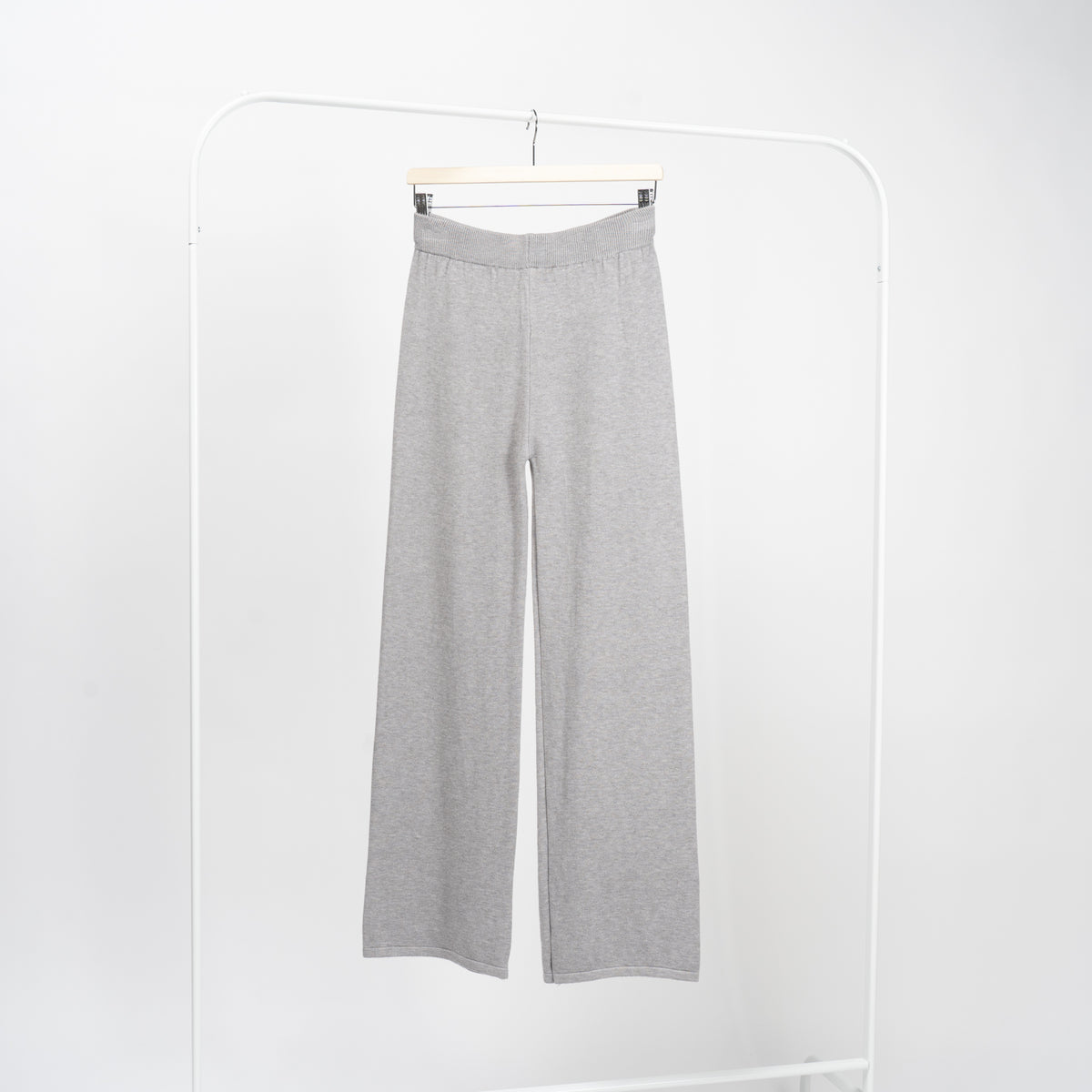 Detaliu de croială la pantaloni drepți gri din tricot, textură fină și finisaje curate.