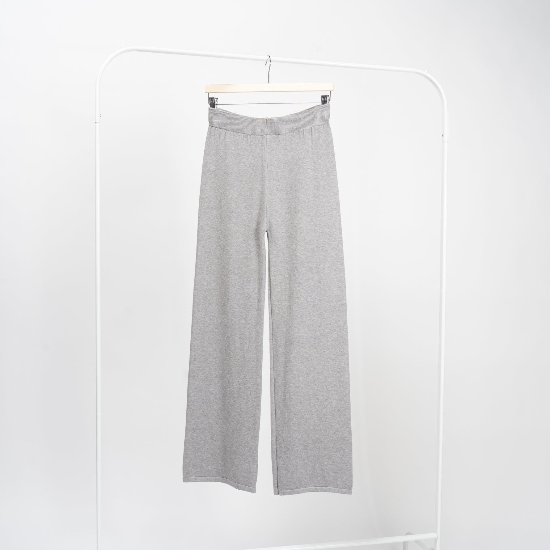 Detaliu de croială la pantaloni drepți gri din tricot, textură fină și finisaje curate.