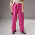 Prim-plan pe talia pantalonilor evazați fucsia din viscoză, cu elastic lat și cordon decorativ, textură ușor creponată.
