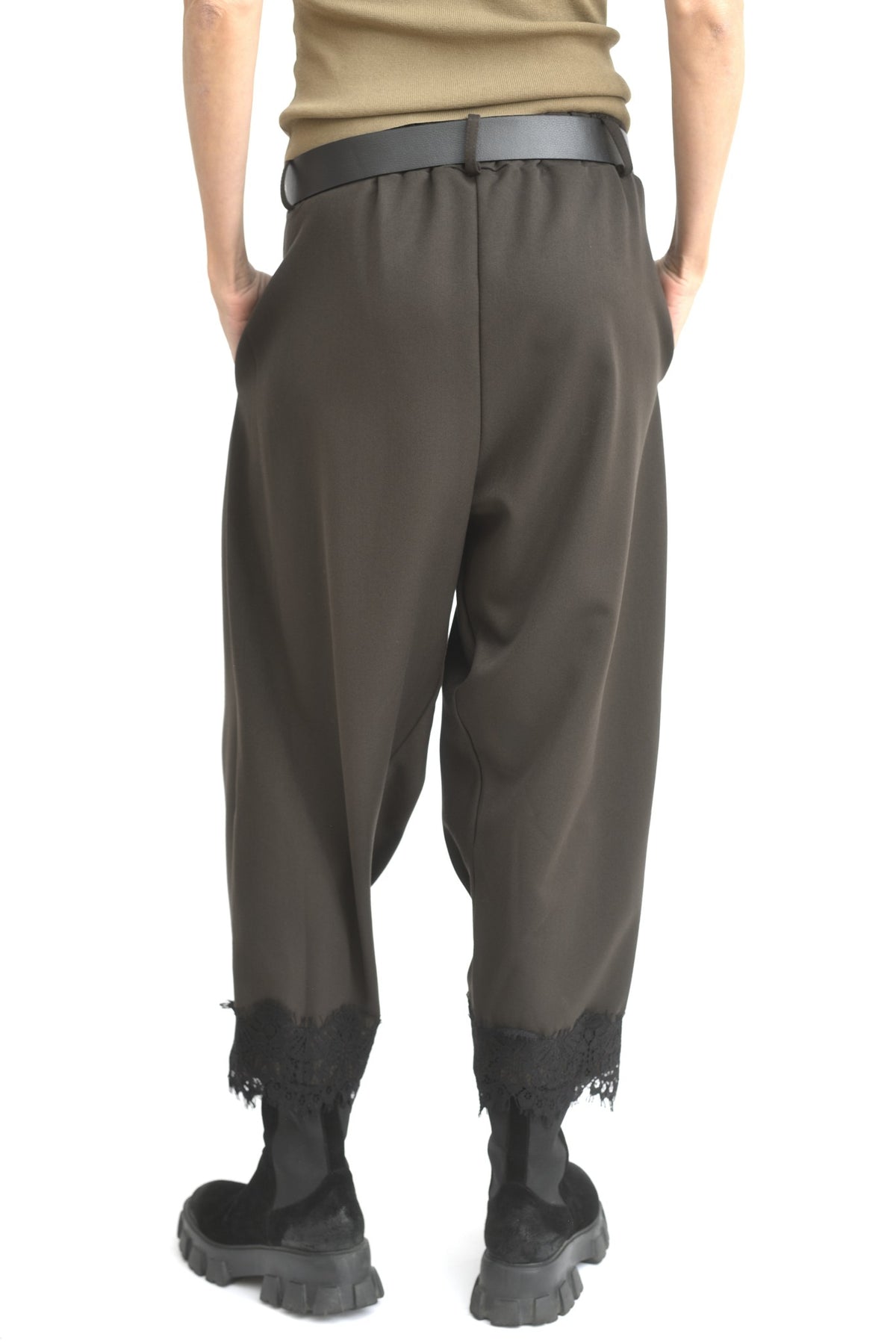 Pantaloni conici maro văzuți din spate, cu croială tip plic și manșete din dantelă.