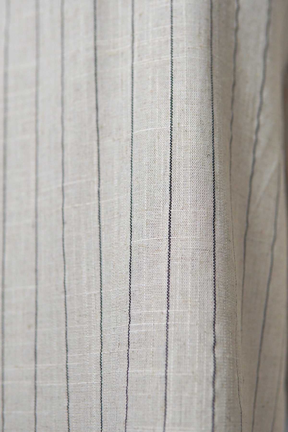 Textura materialului bej cu dungi fine ale pantalonilor lejeri din amestec de in