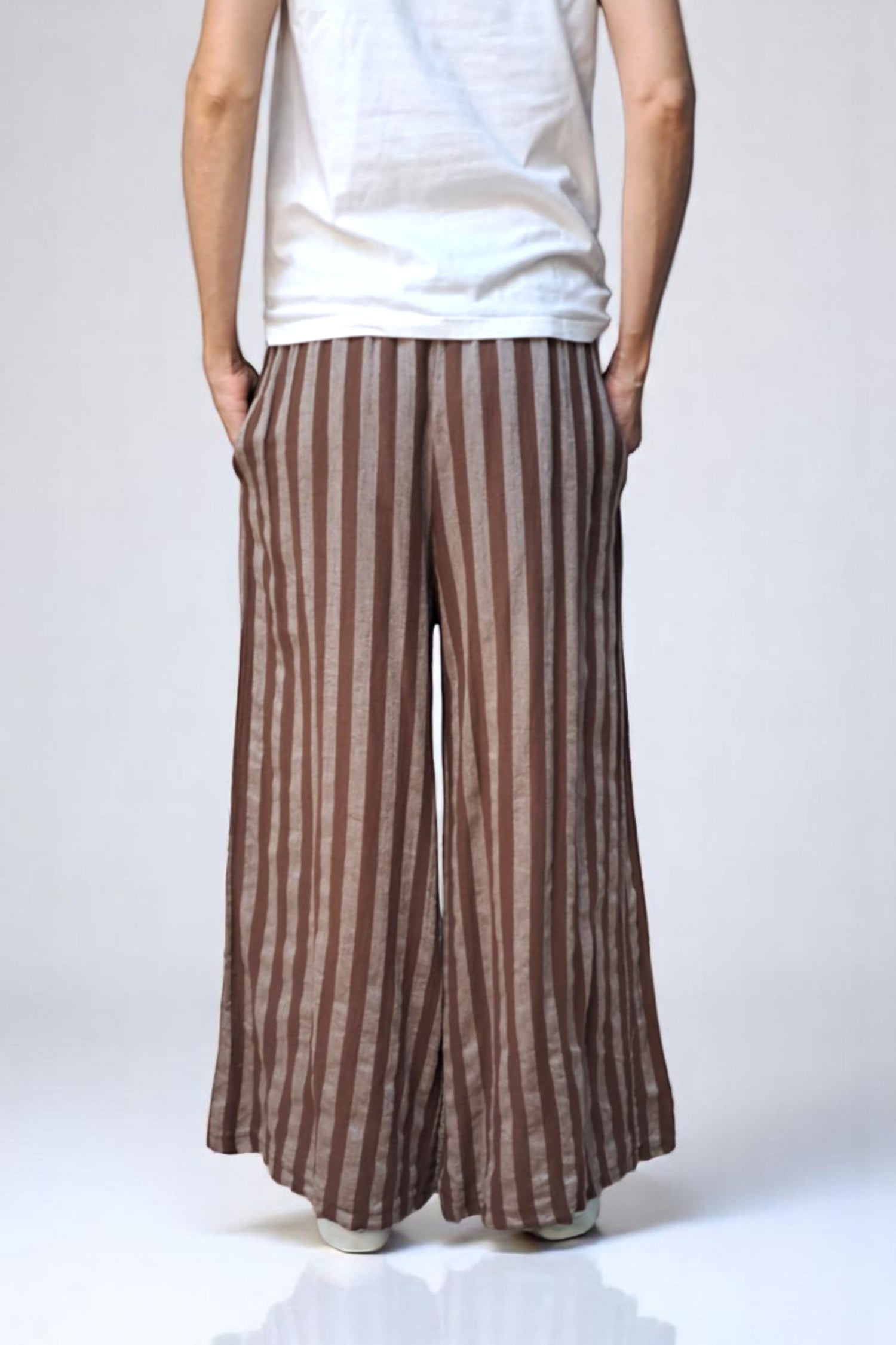 Vedere din spate a pantalonilor casual largi cu dungi verticale în nuanțe de maro
